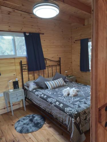 a bedroom with a bed in a log cabin at Cabañas Campos del Parana in San Pedro