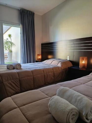 a hotel room with two beds and a window at Achalay Hotel Boutique Colonia Dora in Colonia Dora