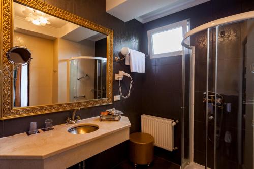 a bathroom with a sink and a mirror and a shower at Weekend Boutique Hotel in Chişinău