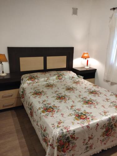 a bedroom with a bed with a floral comforter at Casa Valle Verde in Sierra de los Padres