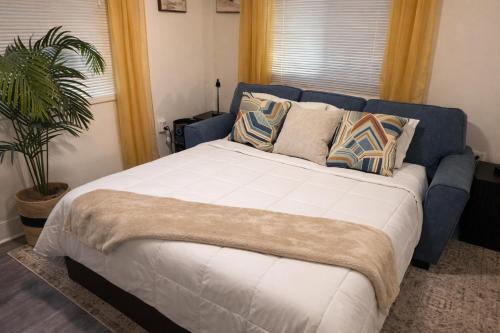a bedroom with a large bed with pillows and a plant at Private King Suite Near DC & Joint Base Andrews in District Heights