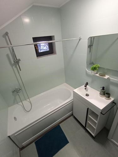 a white bathroom with a tub and a sink at Casa Pop in Oradea