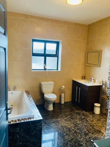 a bathroom with a tub and a toilet and a sink at 2 Bedroom Workers Apartment in Barrysbrook