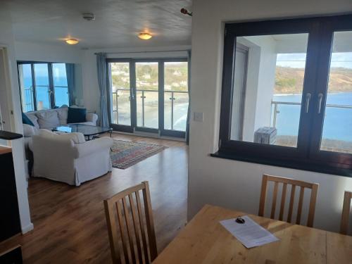 a living room with a table and a couch at Harbour Views, Coverack in Helston