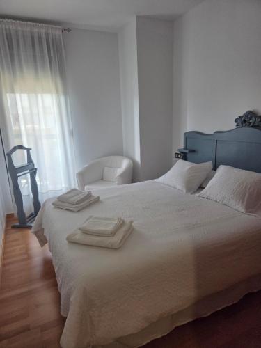 a bedroom with a large bed with towels on it at LUCIA S HOUSE in Mairena del Aljarafe