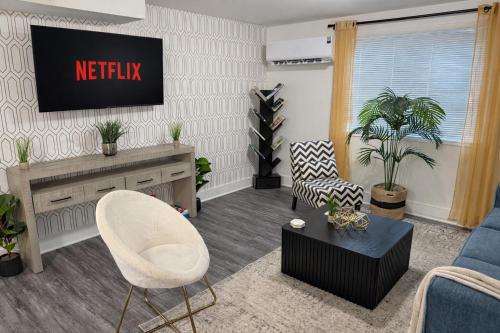 a living room with a tv on a wall at King Suite and Sofa Bed Fast WI-FI Easy DC Access in District Heights