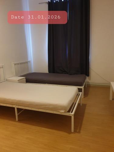 two beds in a room with a window at Monteurwohnung bei Nina 1OGL in Zeitz