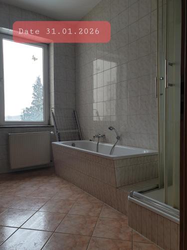 a bathroom with a bath tub and a window at Monteurwohnung bei Nina 1OGL in Zeitz