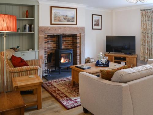 a living room with a fireplace and a couch at Number 23 in Wooler