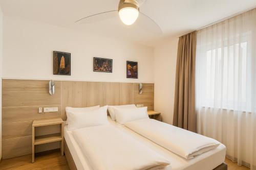 a bedroom with a white bed and a window at Villa Viktoria 3 - Apartments in Ingolstadt