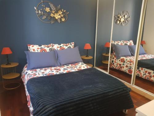 a bedroom with a bed with blue walls and mirrors at Duplex T4 Sempre Endavant in Vernet-les-Bains