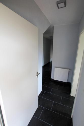 a hallway with a black tile floor and a white wall at Fewo-Baunatal / Ferienwohnung "Am Pilgerbach" in Baunatal