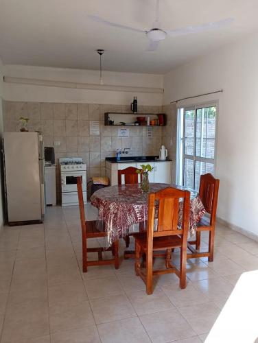 a kitchen with a table and chairs and a refrigerator at Los Pinos de Horizonte in Fernández