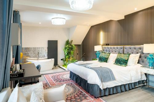 a bedroom with a large bed and a bath tub at Waterhead Bath Suites - Parking and Light Breakfast in Ambleside