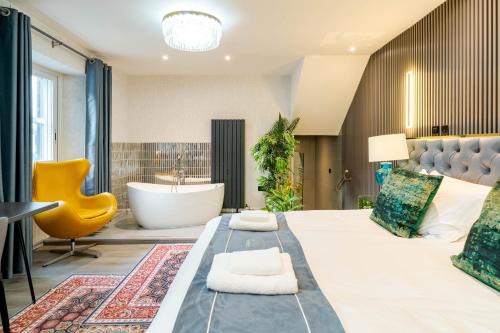 a bedroom with a large bed with a tub and a bathroom at Waterhead Bath Suites - Parking and Light Breakfast in Ambleside