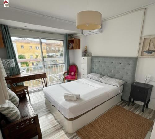 a bedroom with a bed and a desk and a window at Casa con embarcadero in Los Mártires