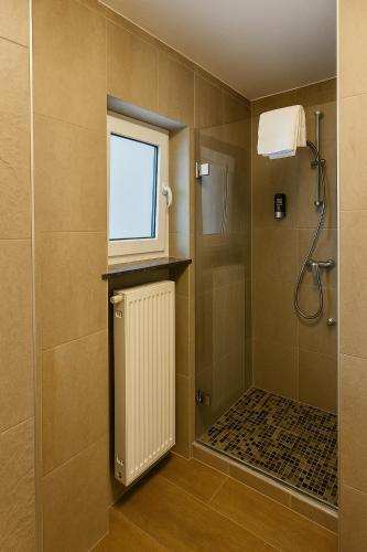 a bathroom with a shower with a window and a radiator at Villa Viktoria 3 - Apartments in Ingolstadt