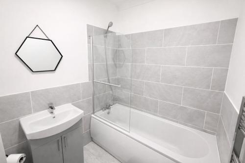 a bathroom with a sink and a tub and a toilet at 4 bedrooms 8 beds Wi-FI smart tv games room in Hull
