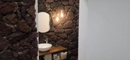 a bathroom with a sink and a mirror at La Cueva de Villa Gardel in Icod de los Vinos