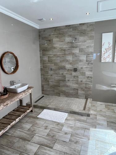 a bathroom with a sink and a mirror at Oppi See Beach House in Wilderness