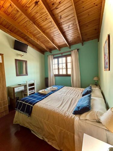 a bedroom with a large bed with a wooden ceiling at Isla Bella in Ushuaia