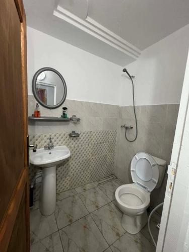 a bathroom with a toilet and a sink and a mirror at La tente in Tamaghzah