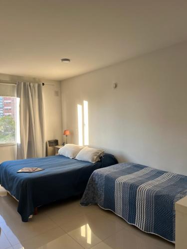 a bedroom with two beds and a window at La Suitte in Bahía Blanca