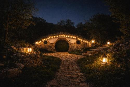 a stone archway with lights in a yard at night at Mobbiton Mostar - Magical Underground Retreat in Mostar