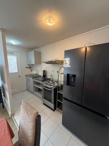a kitchen with a black refrigerator and a stove at Jacinta in Puerto Montt