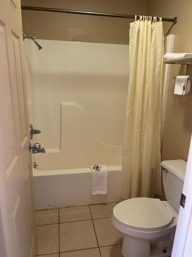a bathroom with a toilet and a bath tub at All Star Inn in Bunkie