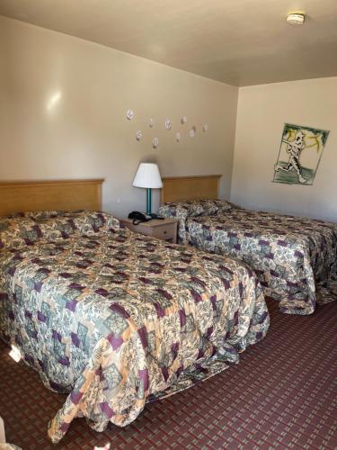 a hotel room with two beds and a lamp at All Star Inn in Bunkie