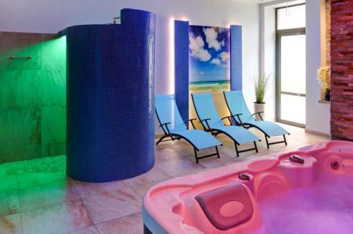 a bathroom with a hot tub and chairs in it at OW Krakus I - pokoje i domki in Stegna
