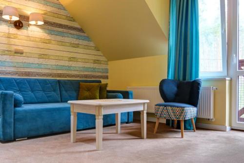 un soggiorno con divano blu e tavolo di OW Krakus I - pokoje i domki a Stegna
