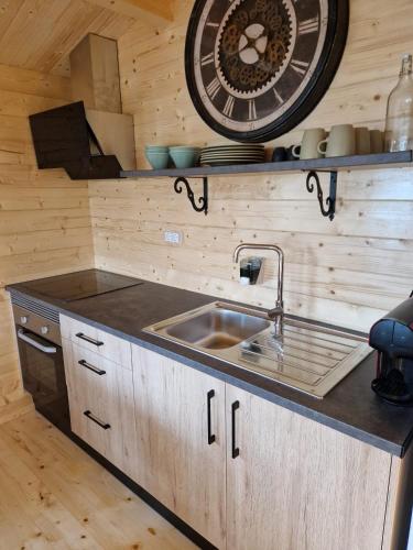 a kitchen with a sink and a clock on the wall at Maria's Village in Tavira