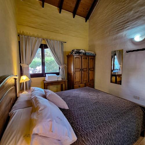 a bedroom with a large bed and a window at Aparts Duendes del Arroyo in Villa General Belgrano
