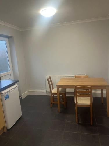 a kitchen with a table and two chairs and a light at Bel City in Thornton Heath