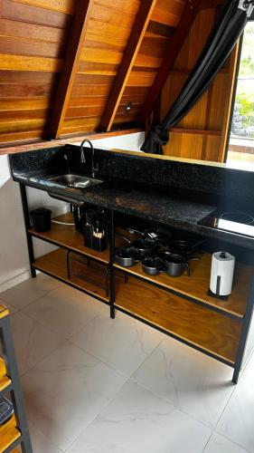a kitchen counter with a sink and a stove at Pousada Estrela Dalva in Piracaia