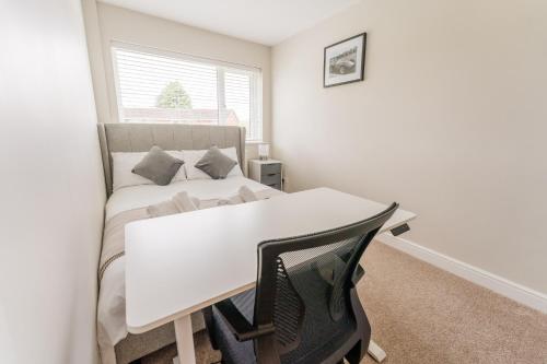 a white bedroom with a bed and a window at Solihull House - Free Parking, NEC, Airport in Solihull
