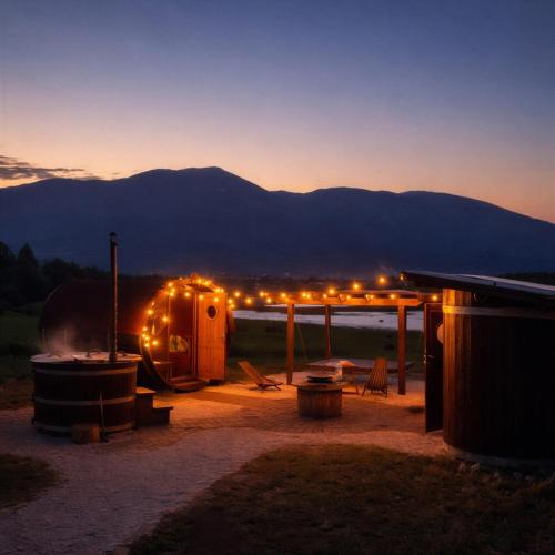 a night view of a camp with a fire at Barrel Land Blidinje - Drvena bačva za spavanje in Posušje