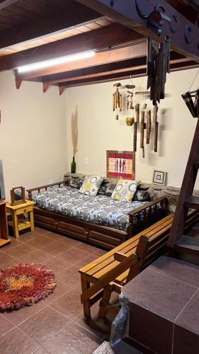 a bedroom with a large bed and a bench at casa rustica dos dormitorios con pileta in Huerta Grande