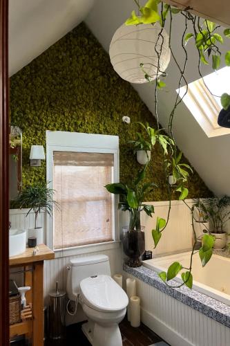 a bathroom with a toilet and plants on the wall at Stylish Mission-Style Home on Park in Jersey City, NJ in Jersey City