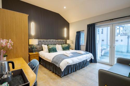 a hotel room with a bed and a balcony at Waterhead Retreat, Ground Floor Bathtub Suites with Private Entrance in Ambleside