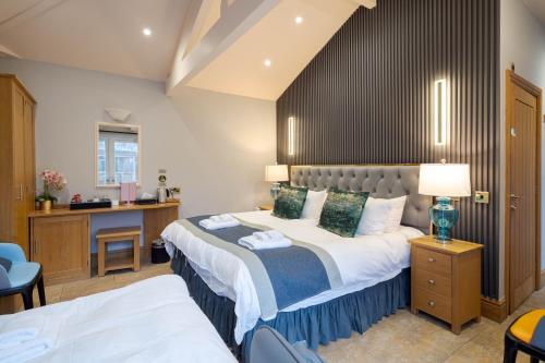 a bedroom with a large bed and a desk at Waterhead Retreat, Ground Floor Bathtub Suites with Private Entrance in Ambleside
