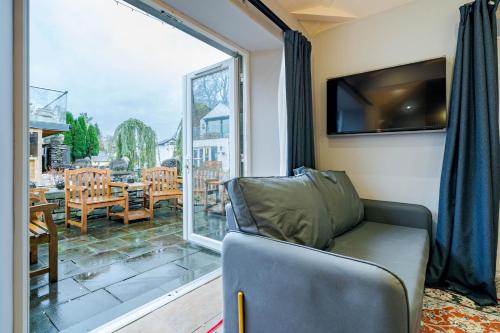 a living room with a couch and a large window at Waterhead Retreat, Ground Floor Bathtub Suites with Private Entrance in Ambleside