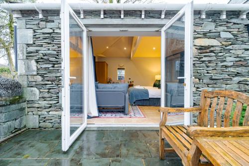 a sliding glass door leading into a room with a bedroom at Waterhead Retreat, Ground Floor Bathtub Suites with Private Entrance in Ambleside