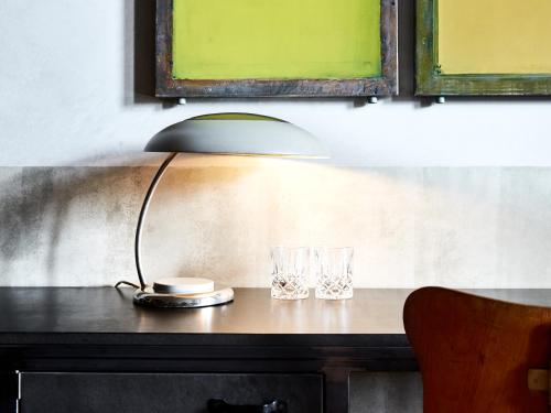 a table with a lamp and two glasses on it at Linnen in Berlin