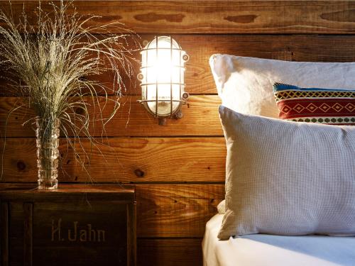 a lamp on a table next to a bed with pillows at Linnen in Berlin