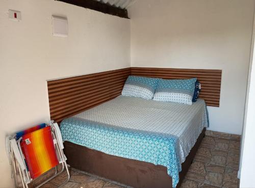 a bedroom with a bed with a wooden headboard at Chalé Pedacinho do Céu in Mairiporã