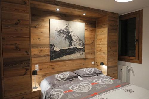 a bedroom with a wooden wall with a bed at Le Cervin Lodge in Breuil-Cervinia