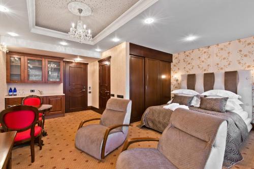 
a hotel room with two beds and a chair at Aqua Center Apartments in Druskininkai
